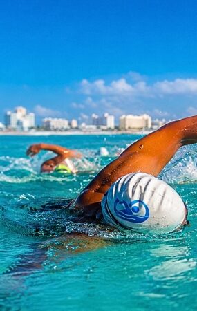 Miles de nadadores nacionales e internacionales participan en una de las competencias acuáticas más importantes de México, celebrada en las aguas turquesa del Caribe.